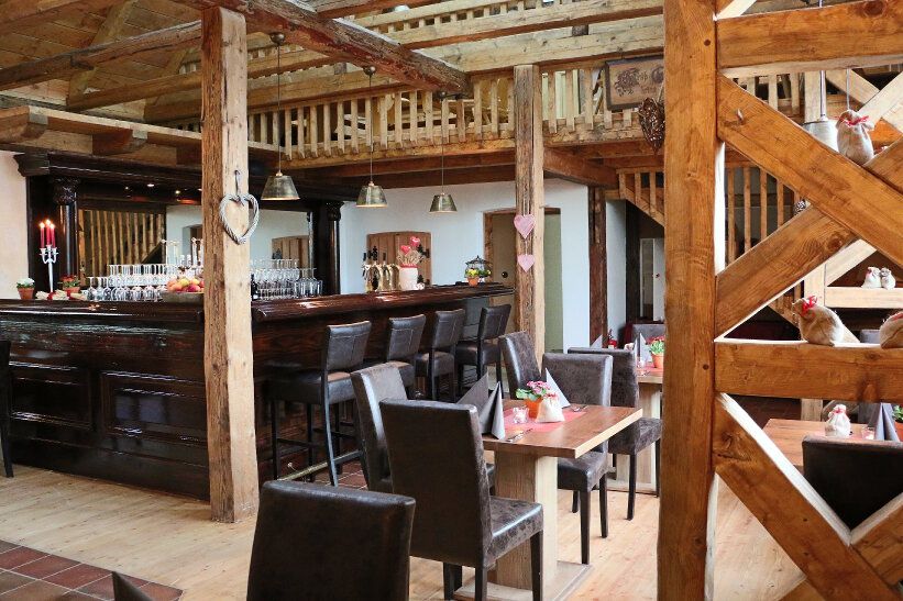 Bar unter Holzbalken mit Galerie in der Mühlenscheune