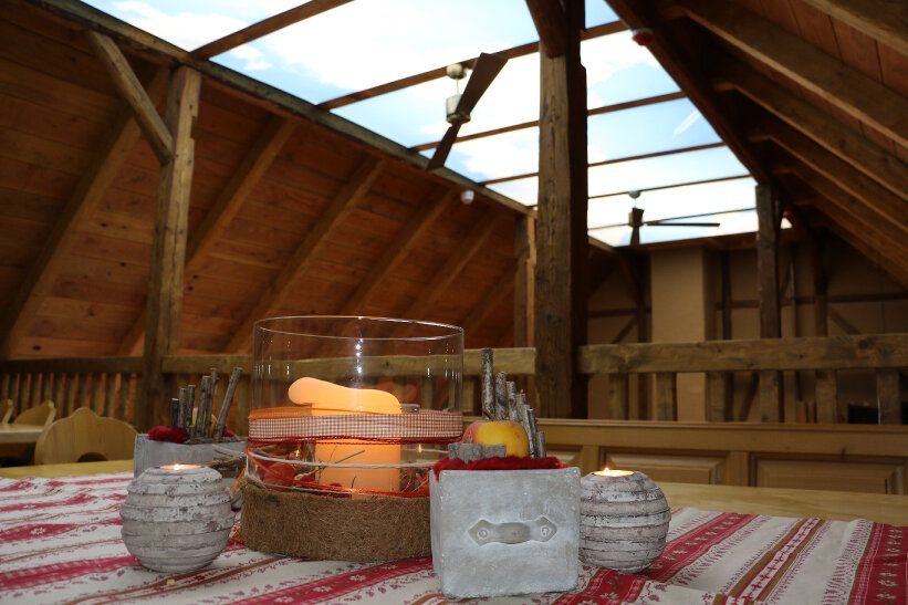 Gedeckter Tisch auf dem Hochsitz unter dem Dachstuhl mit Oberlicht